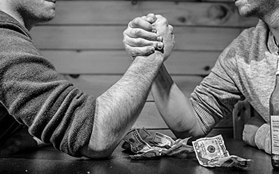 Men arm wrestling over money