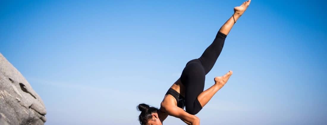 Woman doing yoga by the ocean