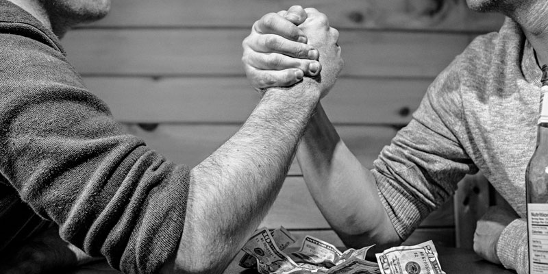 Men arm wrestling over money
